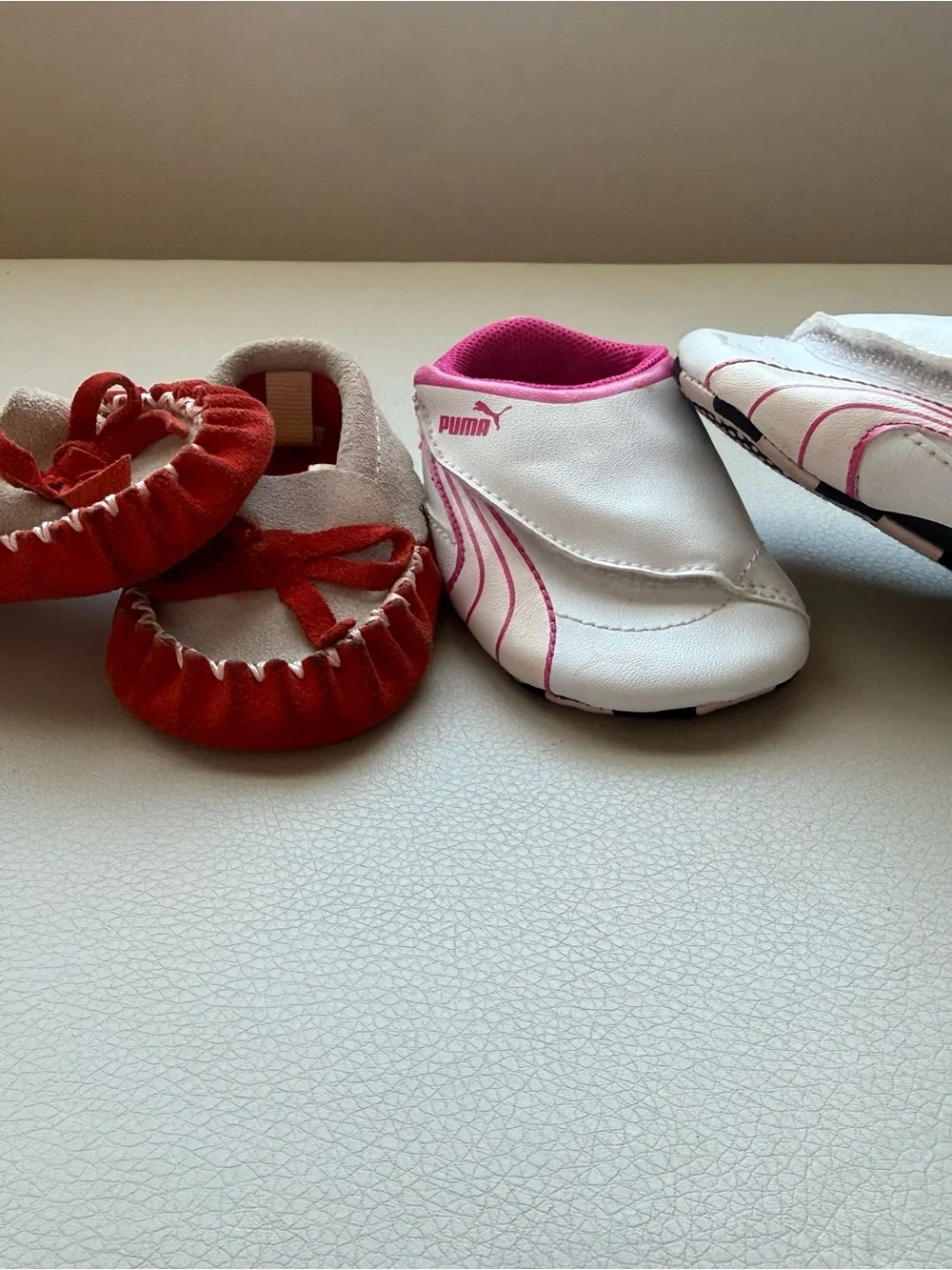 Puma White/ Pink Infant Slip-On Sneakers and brown baby moccasins with orange